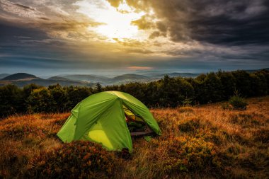 Vahşi Karpat dağlarında güneş ışığında profesyonel turist çadırı