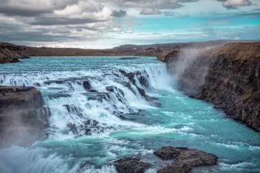 Popüler turizm beldesi Gullfoss Şelalesi manzarası. Muhteşem Hvita nehri. İzlanda. Seyahat ve tatil teması