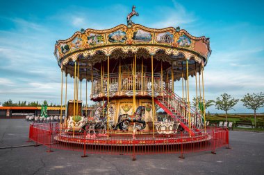 Old children's carousel on abandoned funfair at sunset
