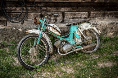 The old and rusty abandoned motorcycle moped. Transportation theme