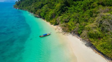 Sandy beach with beautiful sea water and long-tail boats on the pristine white beach of Bat Island in the Andaman Sea of Ranong Province, southern Thailand, Asia clipart