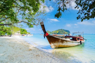 Kumsal ve uzun kuyruklu tekneler Krabi 'nin güney denizindeki kumlu sahil boyunca demirlediler, Tayland, Asya