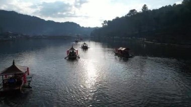 Güneşin doğuşunun tadını çıkarmak için tatlı su gölünde yerel bir tekne turuna çık. Baan Rak Thai, Mae Hong Son Eyaleti, Kuzey Tayland, Asya 'da atmosfer çok güzel..