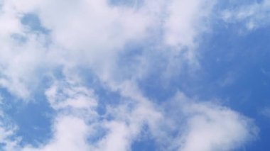 Açık bir günde mavi gökyüzünde beyaz bulutlar dolaşıyor..