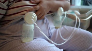 Anne süt pompalıyor ve bebeğin içmesi için şişeye koyuyor.