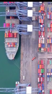 Derin deniz limanları, dünya çapında nakledilmek üzere içerideki kargo gemilerine mallarla dolu konteynırlar yüklüyor..