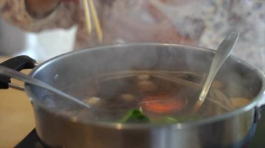 Elektrikli tencerede shabu shabu ya da sukiyaki sebze çorbası yemek. Sıcak Çömlek