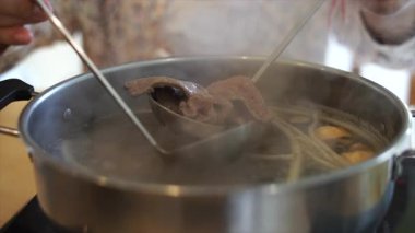 Elektrikli tencerede shabu shabu ya da sukiyaki sebze çorbası yemek. Sıcak Çömlek