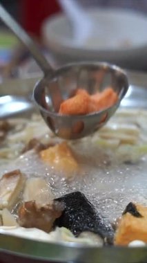 Tencerede sukiyaki yemek.