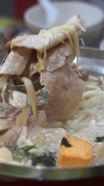 Tencerede sukiyaki yemek.