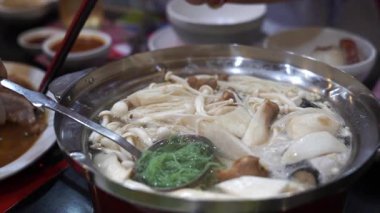 Tencerede sukiyaki yemek.