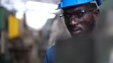 Bir mühendis ya da teknisyen eski bir sanayi fabrikasında bir sanayi makinesini ya da torna torbasını inceliyor..