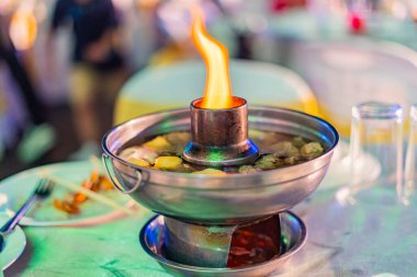 Tom Yum Tayland yemeğiyle birlikte yemek masasında sıcak çömlek