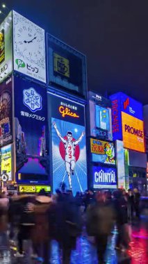 Dikey video OSAKA, JAPAN: Dotonbori 'nin zamanlayıcı görüntüsü gece. Neon ışıklarıyla dolu ana turizm merkezleri