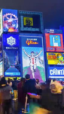 Dikey video OSAKA, JAPAN: Dotonbori 'nin zamanlayıcı görüntüsü gece. Neon ışıklarıyla dolu ana turizm merkezleri