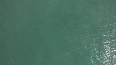 Temiz yeşil deniz suyunun üzerinde uçan İHA 'nın hava görüntüsü.