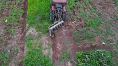 İnsansız hava aracı çiftçileri çiftçilik için tarlayı sürmek için traktör kullanıyorlar..