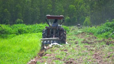 Yavaş çekim video çiftçileri çiftçilik için tarlayı sürmek için traktörler kullanıyorlar..