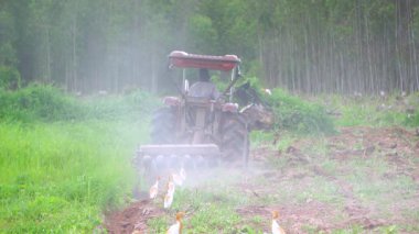 Yavaş çekim video çiftçileri çiftçilik için tarlayı sürmek için traktörler kullanıyorlar..