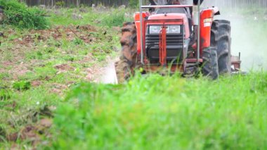 Yavaş çekim video çiftçileri çiftçilik için tarlayı sürmek için traktörler kullanıyorlar..