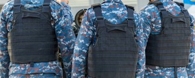 Kurşun geçirmez yelek giyen askerler görevlerini yapıyorlar..