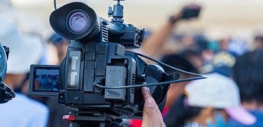 Bir fotoğrafçı haberleri iletmek için kamera kullanıyor..