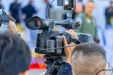 Bir fotoğrafçı haberleri iletmek için kamera kullanıyor..