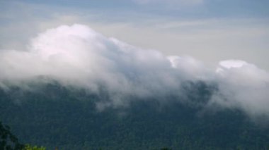 Yağmur mevsimi sabahında çok sayıda bulut dağın tepesinde yüzüyor..