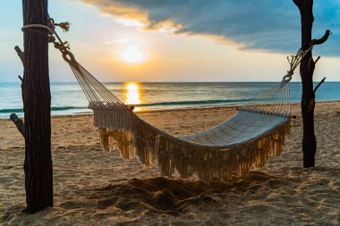 Kumsalda gün batımında uzanmak için rahatlatıcı bir hamak. Long Beach, Lanta Adası veya Koh Lanta, Krabi Eyaleti Tayland