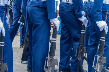 Askerler hizmet tüfekleriyle geçit töreni yapıyorlar..