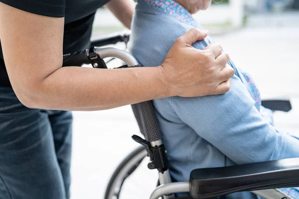 stock image Caregiver help and care Asian senior or elderly old lady woman patient sitting on wheelchair at nursing hospital ward, healthy strong medical concept