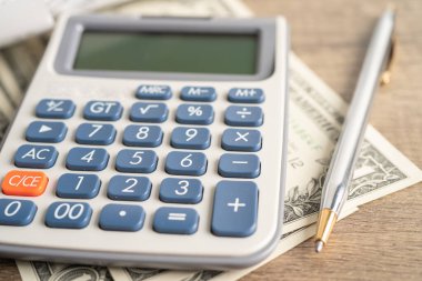 Hesap makineli alışveriş listesi makbuzları ve Amerikan doları banknotları..