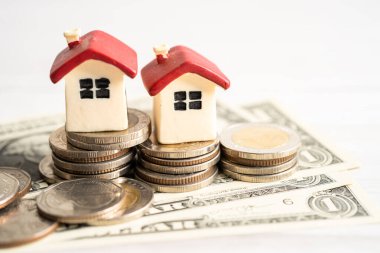 Madeni para, ev kredisi, tasarruf planı, taksitlendirme finansmanı ve bankacılık kavramı üzerinde bitki yetiştiren ev modeli.