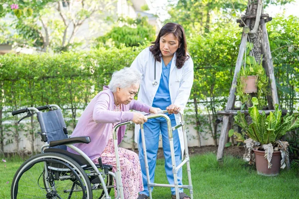 Doctor help and care Asian senior or elderly old lady woman patient sitting on wheelchair at park in nursing hospital ward, healthy strong medical concept.