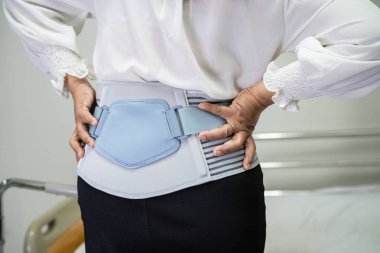 Ortopedik bel kemiği için sırt ağrısı destek kemeri takan Asyalı bir hasta..