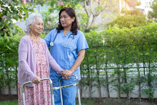 stock image Doctor help and care Asian senior or elderly old lady woman use walker with strong health while walking at park in happy fresh holiday.