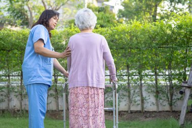 Doktor yardım ve bakım Asyalı yaşlı yaşlı ya da yaşlı kadın sağlıklı bir şekilde parkta yürürken yürüyüş yapıyor..