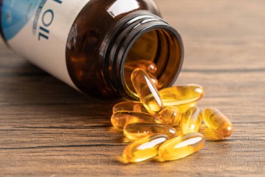 Balık yağı Omega 3 kapsülleri EPA ve DHA vitaminleri ahşap arka planda izole edilmiş..