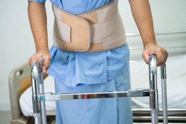 Ortopedik bel kemiği için sırt ağrısı destek kemeri takan Asyalı bir hasta..