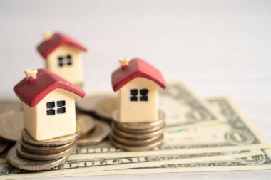 House model with stack of coin money, home loan, saving plan, installment payment finance and banking concept.