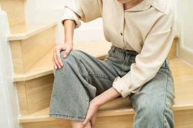 Asyalı kadın hasta kaygan yüzeyler yüzünden merdivenlerden düşüyor.