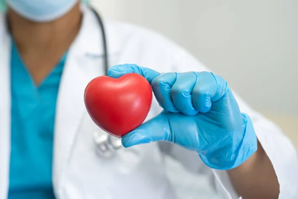 Doctor holding red heart, healthy strong medical concept.