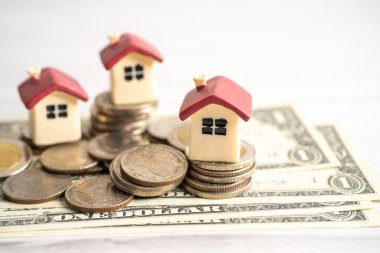 House model with stack of coin money, home loan, saving plan, installment payment finance and banking concept.