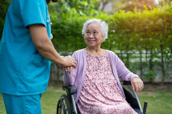 医師のヘルプとケアアジアの高齢女性患者は 介護病院区の公園で車椅子に座って 健康的な強い医療の概念 — ストック写真