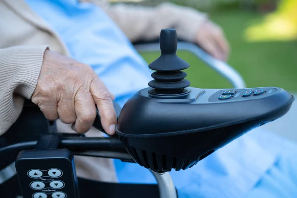医院里坐在电动轮椅上 手持操纵杆和遥控的亚洲老年妇女患者 — 图库照片