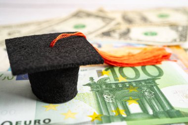 Avrupa ve ABD doları üzerindeki mezuniyet şapkası para, eğitim ücreti öğrenim öğrenimi öğretim konsepti.