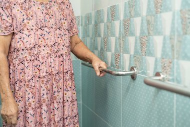 Asian senior or elderly old lady woman patient use toilet bathroom handle security in nursing hospital, healthy strong medical concept.