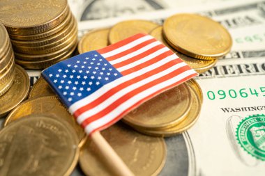 Beyaz arka planda Amerikan bayrağı olan bozuk para yığını.