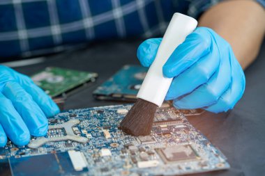 Asyalı teknisyen fırça, donanım, cep telefonu, güncelleme konsepti ile akıllı telefon elektronik teknolojisinin kirli mikro devre tamiri ve temizliği.