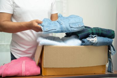 Dünyada fakir insanlara yardım etmek için evde giysi ve kullanılmış giysiler taşıyan gönüllü bir kadın var..